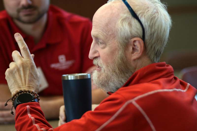 a man in red shirt holding a cup