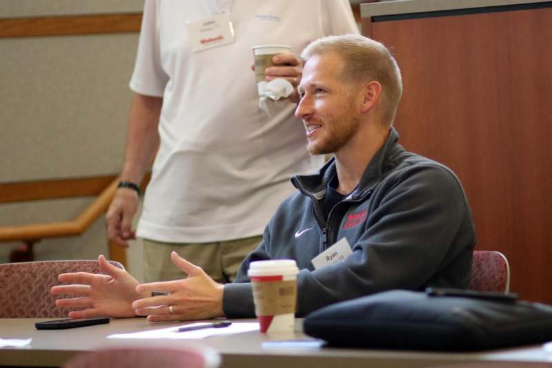 a man sitting at a table with a man talking