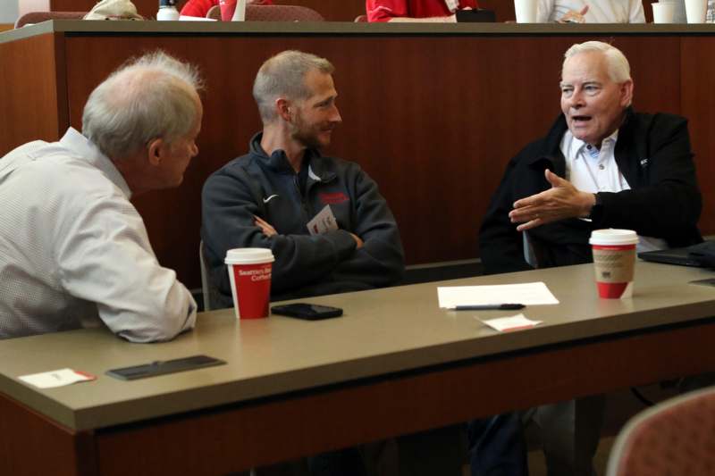 a group of men sitting at a table talking