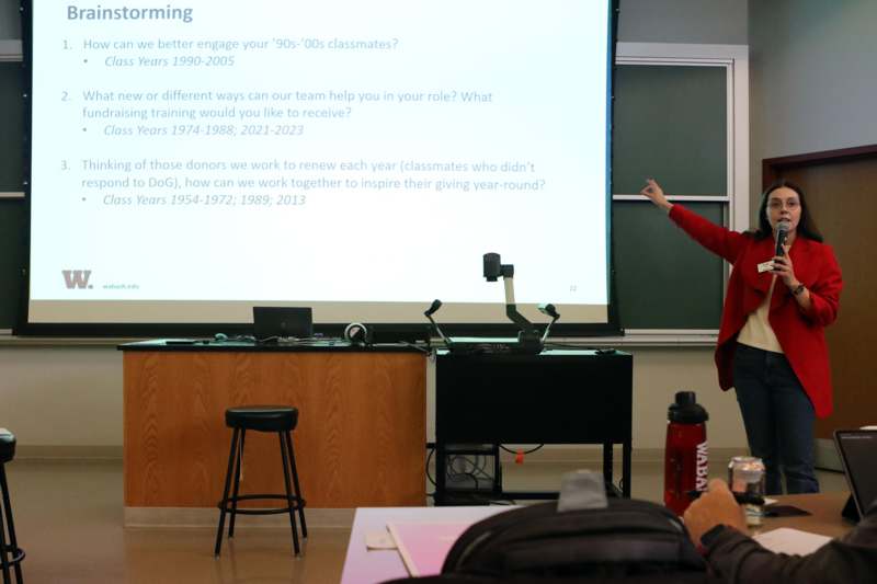 a woman standing in front of a projection screen