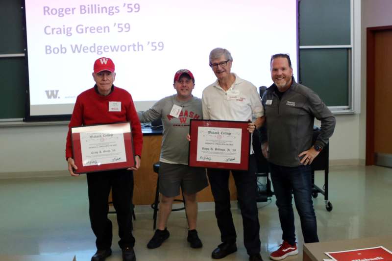 a group of men holding certificates