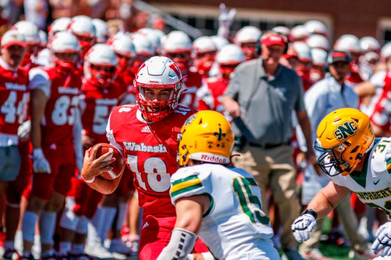 a football player in a red uniform holding a football