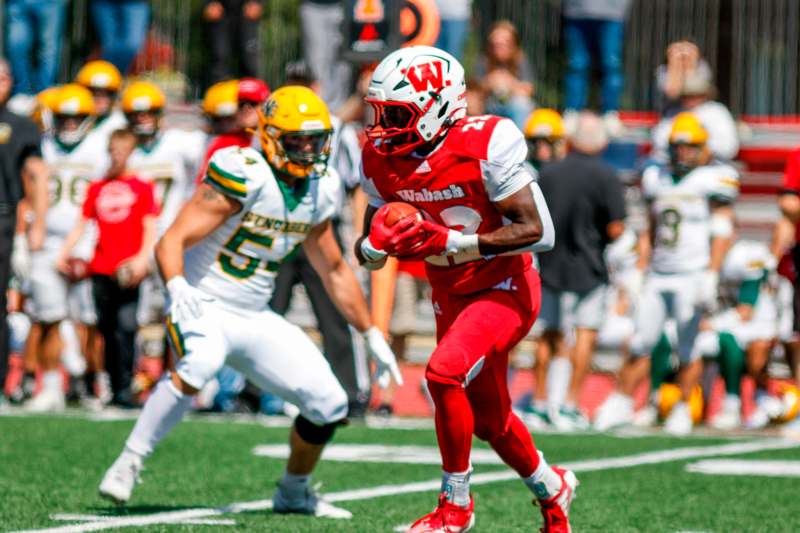 a football player running with a football in the background