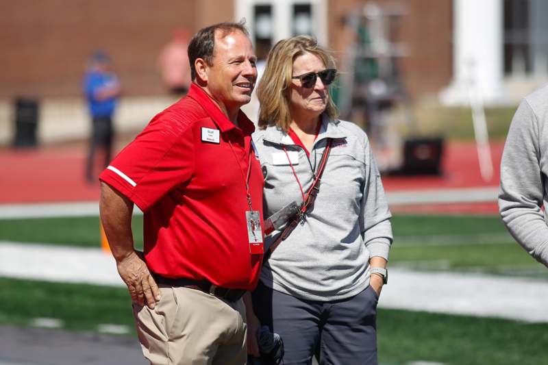 a man and woman standing on a football field