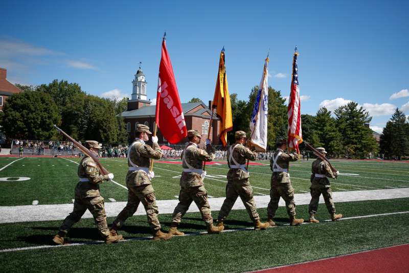 a group of soldiers marching on a football field