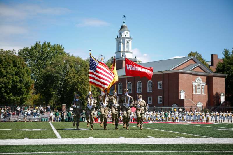 a group of soldiers holding flags on a football field