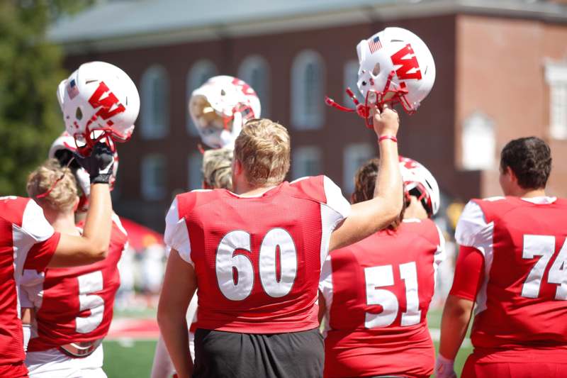 a group of people holding football helmets