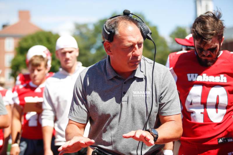 a man wearing headphones and talking to a group of people