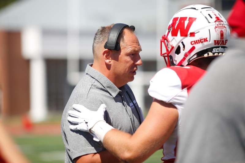 a football coach talking to a football player