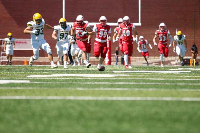 a group of football players running on a field