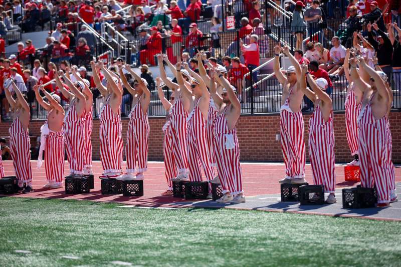 a group of people wearing striped overalls on a field