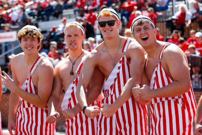 a group of men wearing striped overalls and white hats