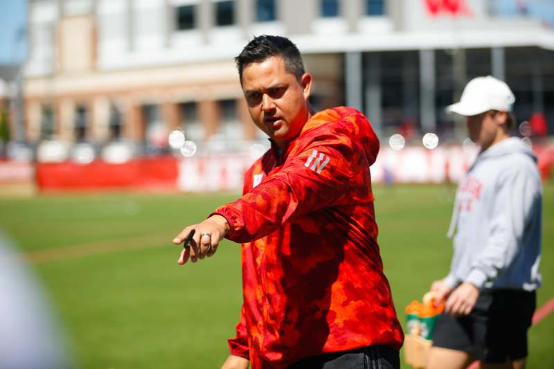 a man in a red jacket pointing at something