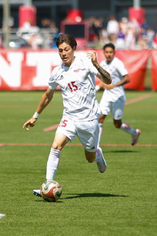 a man in white uniform kicking a football ball