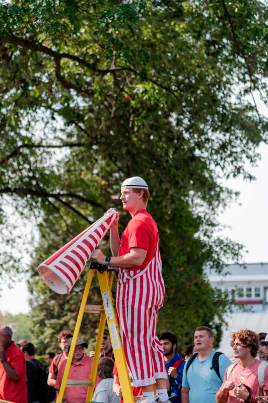 a man on a ladder holding a megaphone