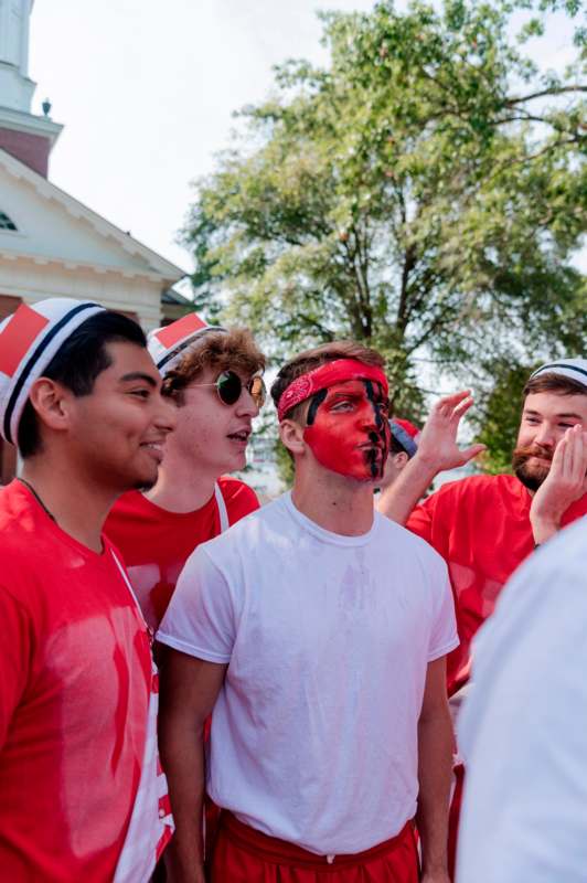 a group of men wearing red shirts and white hats