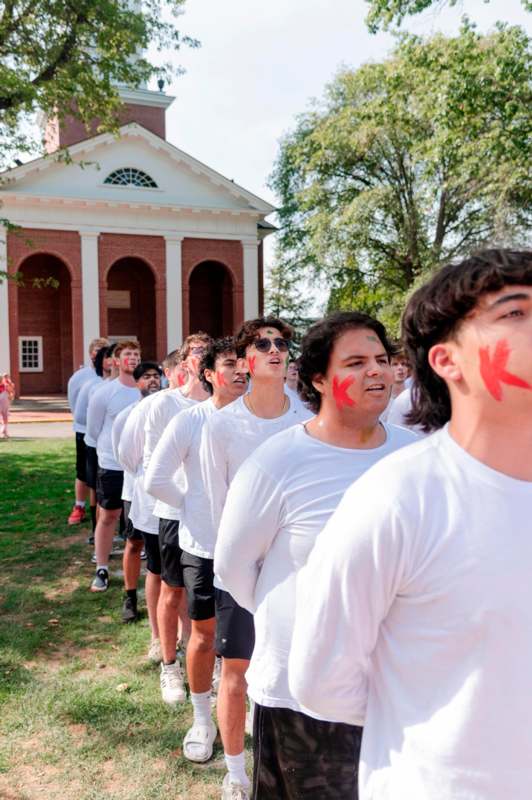 a group of people standing in a line with red arrows on their faces