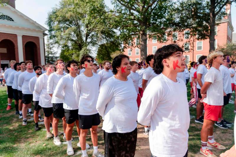 a group of people in white shirts with red paint on their faces