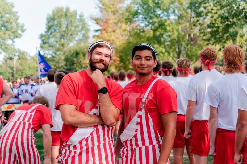 two men in red and white striped overalls standing in a crowd