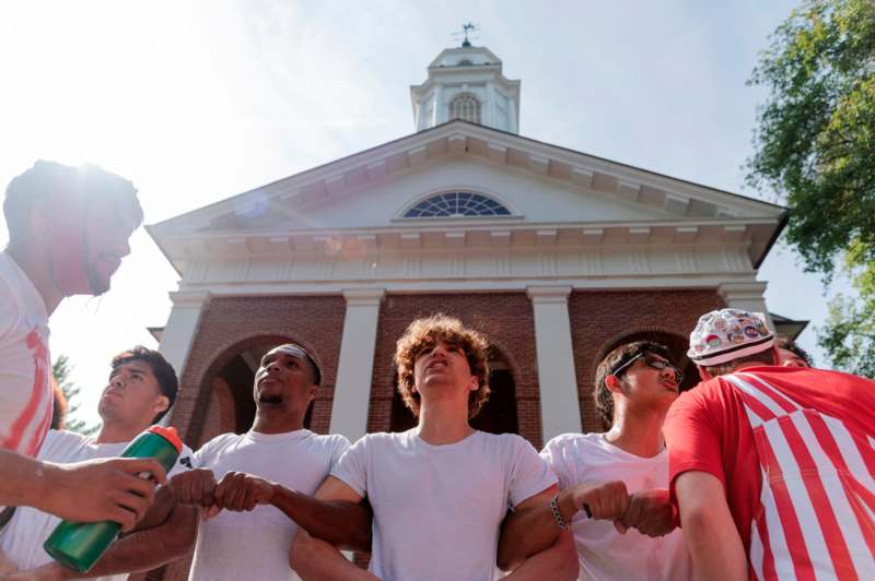 a group of men holding hands in front of a building