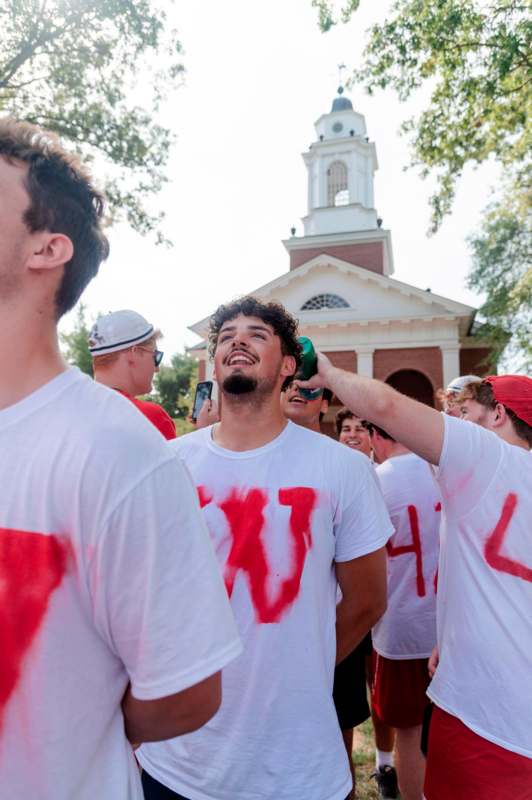 a group of people wearing white t-shirts with red letters on them