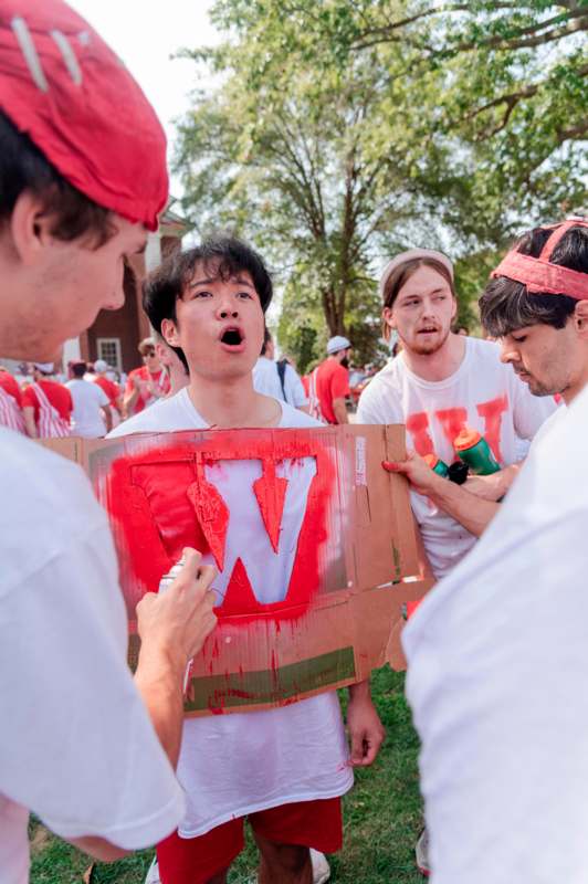 a group of people in white shirts with red paint on their shirts