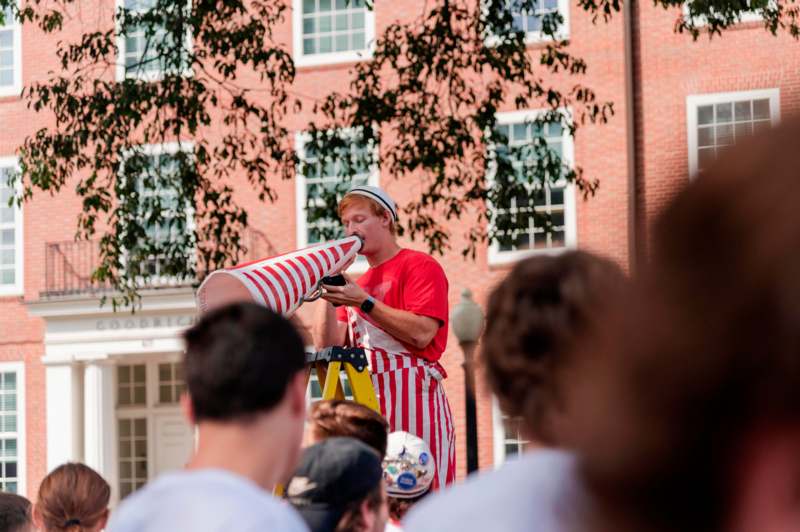 a man in striped apron blowing a tube