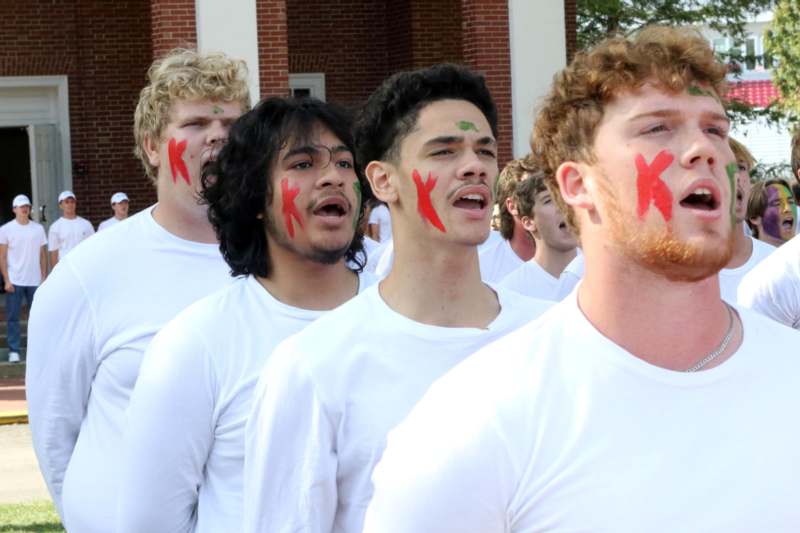 a group of men wearing white shirts with k on their faces