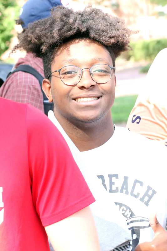 a man with curly hair wearing glasses