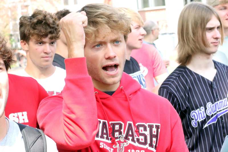 a man in a red sweatshirt with his fist up