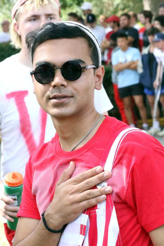 a man wearing sunglasses and holding his hand on his chest