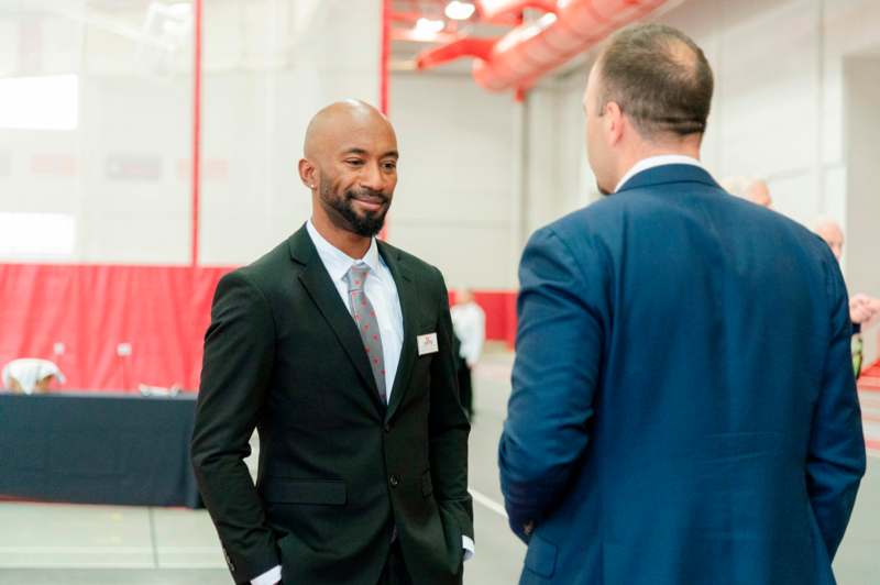 a man in a suit talking to another man