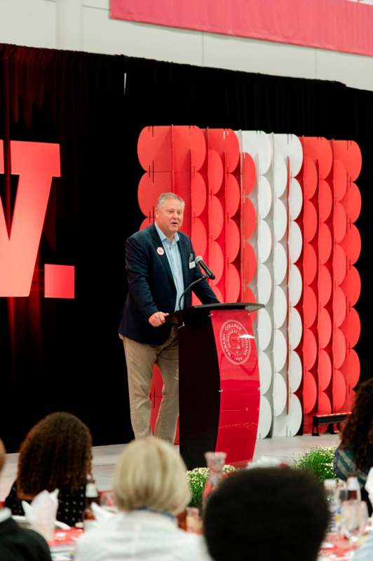 a man standing at a podium with a microphone