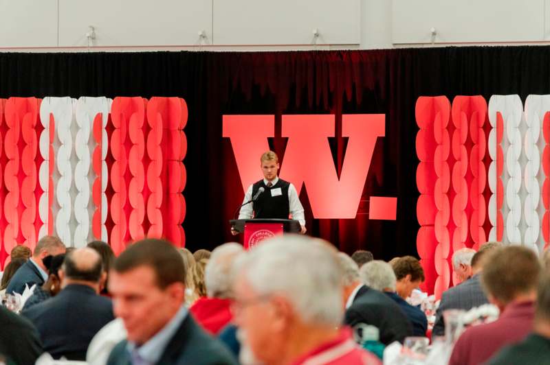 a man standing at a podium in front of a crowd of people