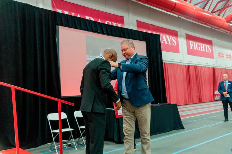 two men shaking hands in a room