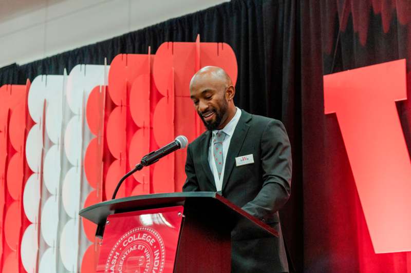 a man standing at a podium with a microphone