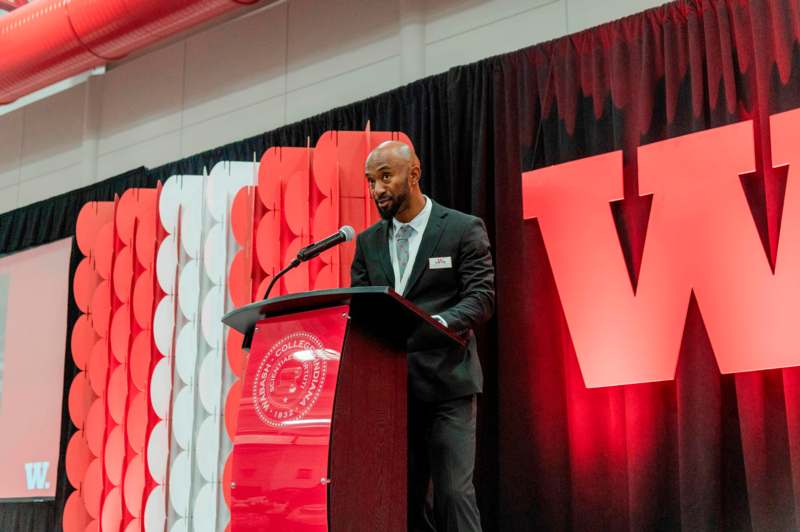 a man standing at a podium with a microphone