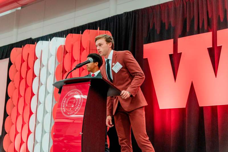 a man standing at a podium with a microphone