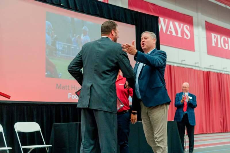 two men in suits on a stage