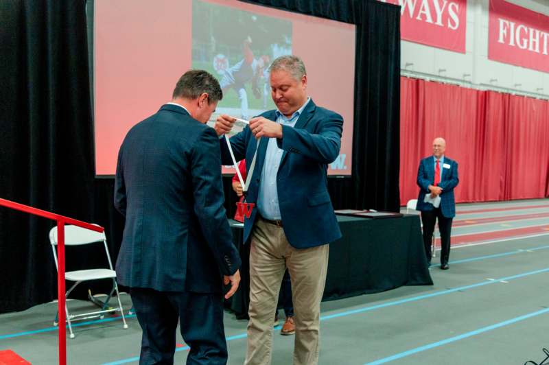 a man in suit holding a medal