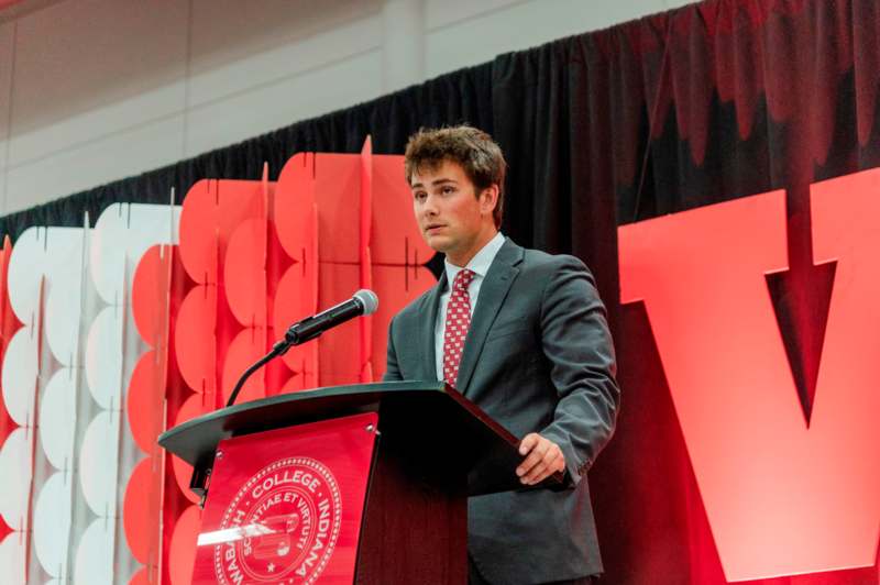 a man standing at a podium with a microphone