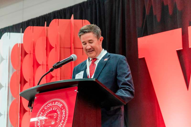 a man standing at a podium with a microphone