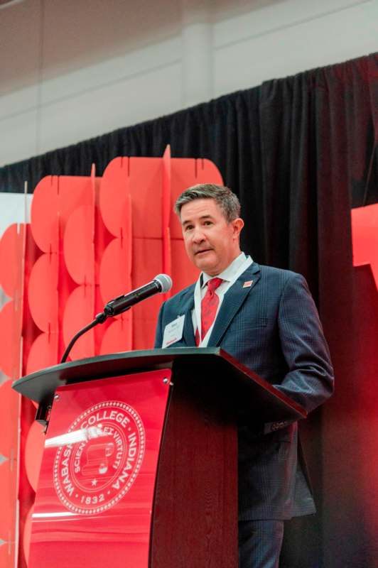 a man standing at a podium with a microphone