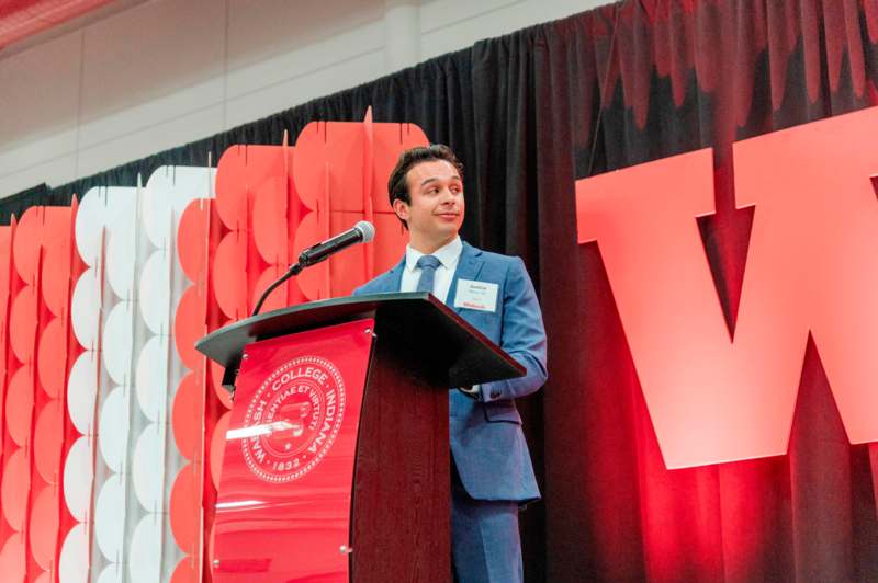 a man standing at a podium with a microphone