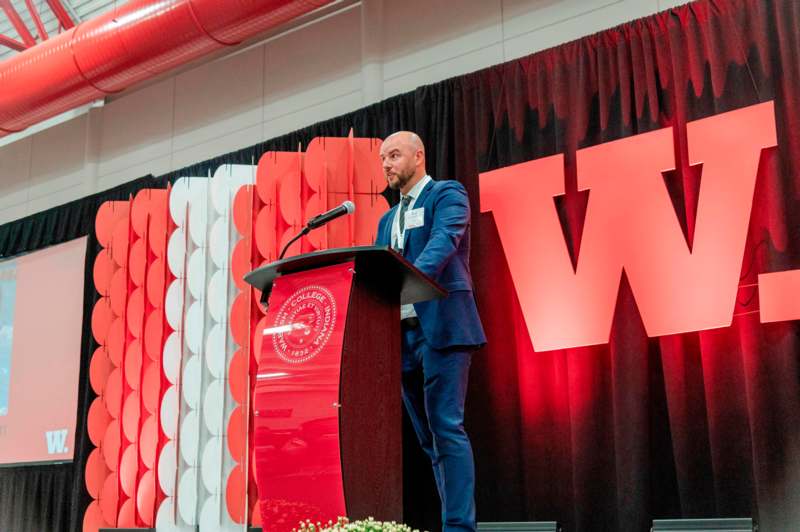 a man standing at a podium with a microphone