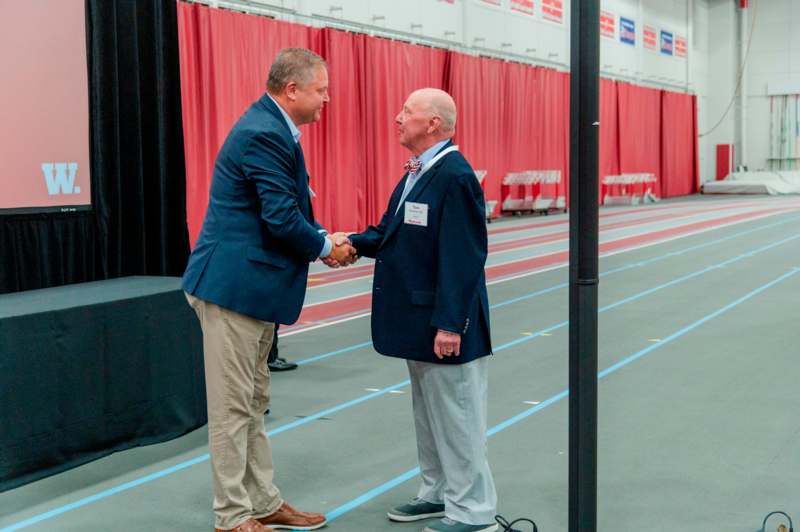 two men shaking hands in a room