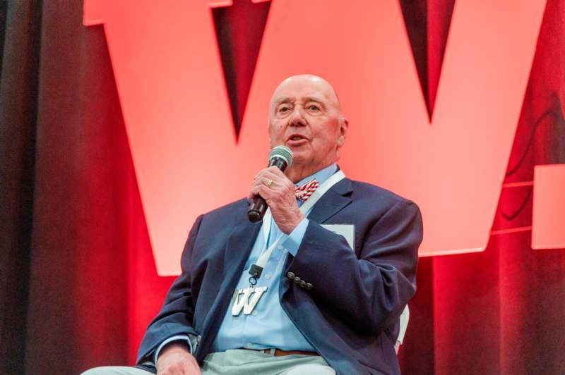 a man sitting in a chair holding a microphone