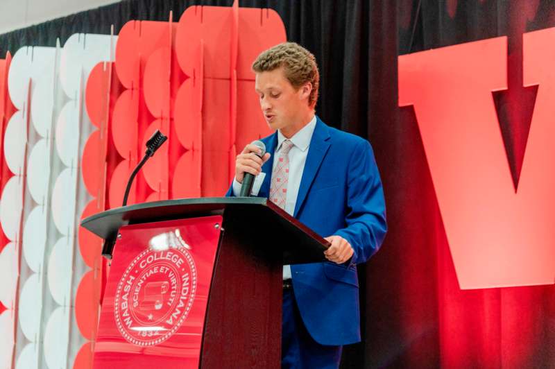 a man standing at a podium with a microphone