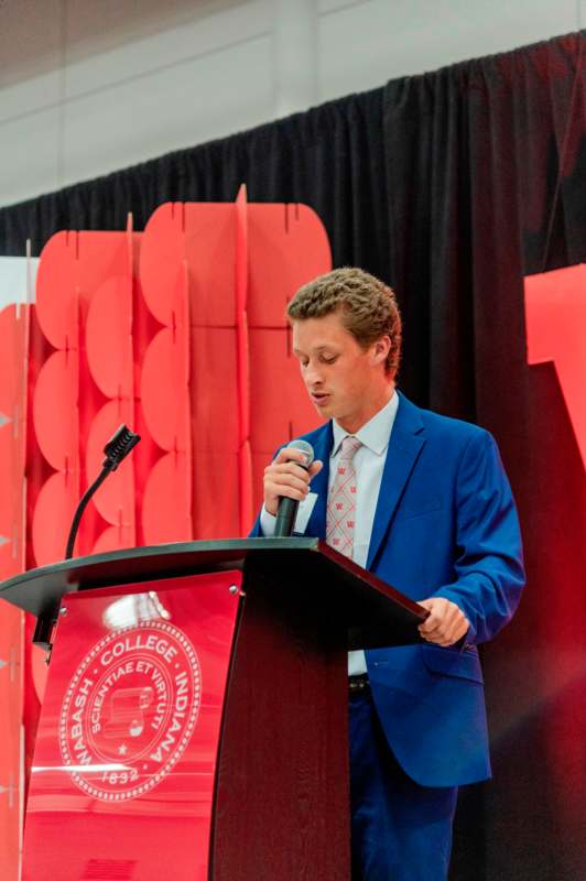 a man standing at a podium with a microphone