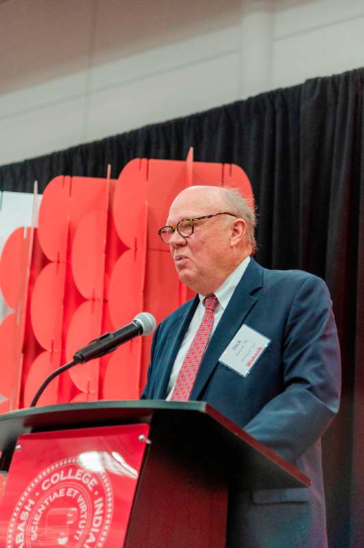 a man standing at a podium with a microphone